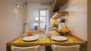 A breakfast table set with plates, cutlery, and a fruit bowl. - Luxury Apartment Lina - I (Dubrovnik)