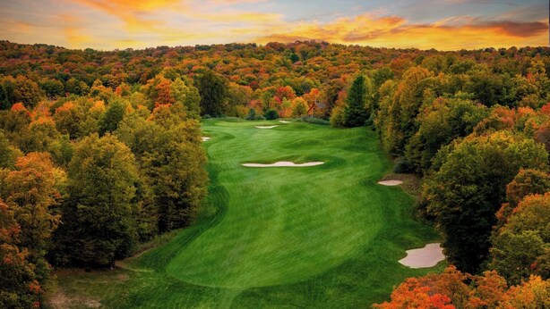 Un parcours de golf entouré d’un paysage automnal.