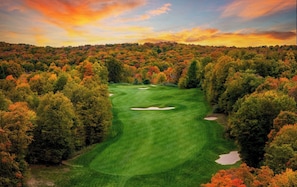 Un campo de golf rodeado de follaje otoñal.