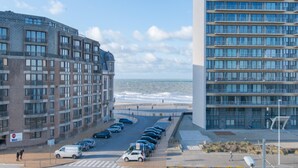 Ein Hotel an der Küste mit mehreren Etagen, einem Parkplatz und Meerblick.
