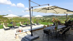 An outdoor patio with stone flooring, outdoor furniture, and umbrellas providing shade. - Ultra-luxurious 6-bedroom villa with AC, WiFi in marvelous Piemonte (Piemonte)