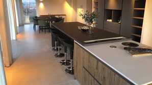 A modern kitchen with a central island, bar stools, a dining area with chairs, and built-in shelves. - Ultra-luxurious 6-bedroom villa with AC, WiFi in marvelous Piemonte (Piemonte)