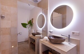 A modern bathroom with two sinks, each with a large oval mirror and a stone basin. - Villa With Salt Water Pool (Palma de Mallorca)