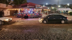 A brightly lit street food stall with a colorful exterior and a sign that reads "KUKA KUKA KUKA".