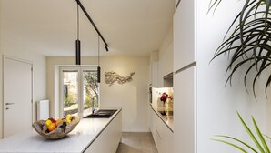 Une cuisine moderne avec un îlot central, une fenêtre et une plante.