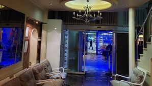 A hotel lobby with a reception desk, seating area, and a chandelier. - GOLDEN ELİT OTEL (Bandirma)