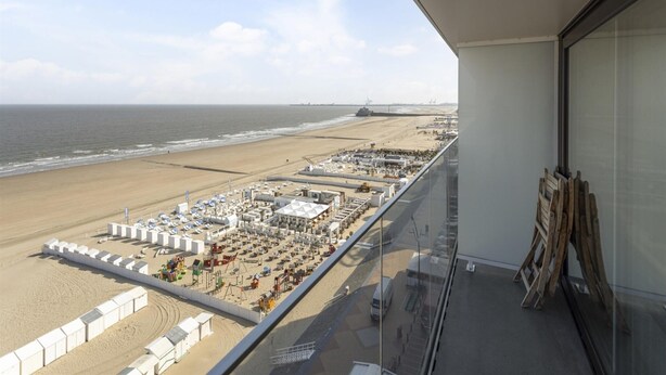 Ein Balkon mit Blick auf Strand und Hafen.