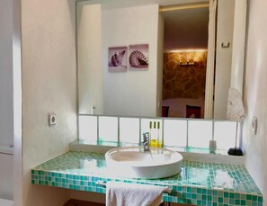 A bathroom with a white sink, green mosaic tiles, a mirror, and a towel. - Villa With Private Pool (Sant Cebria de Vallalta)
