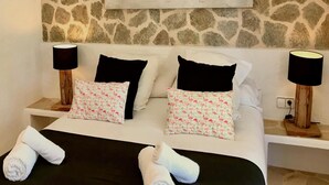A bed with white bedding, black and pink pillows, and two bedside lamps. - Villa With Private Pool (Sant Cebria de Vallalta)