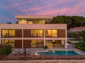 A modern two-story house with a swimming pool, large windows, and a balcony. - Villa Remi (Selca)