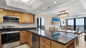 A modern kitchen with stainless steel appliances, wooden cabinets, and a large island.