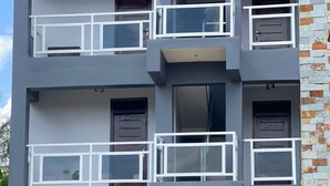 Ein mehrstöckiges Gebäude mit Balkonen, einer Stein-Fassade und einer Eingangstür.