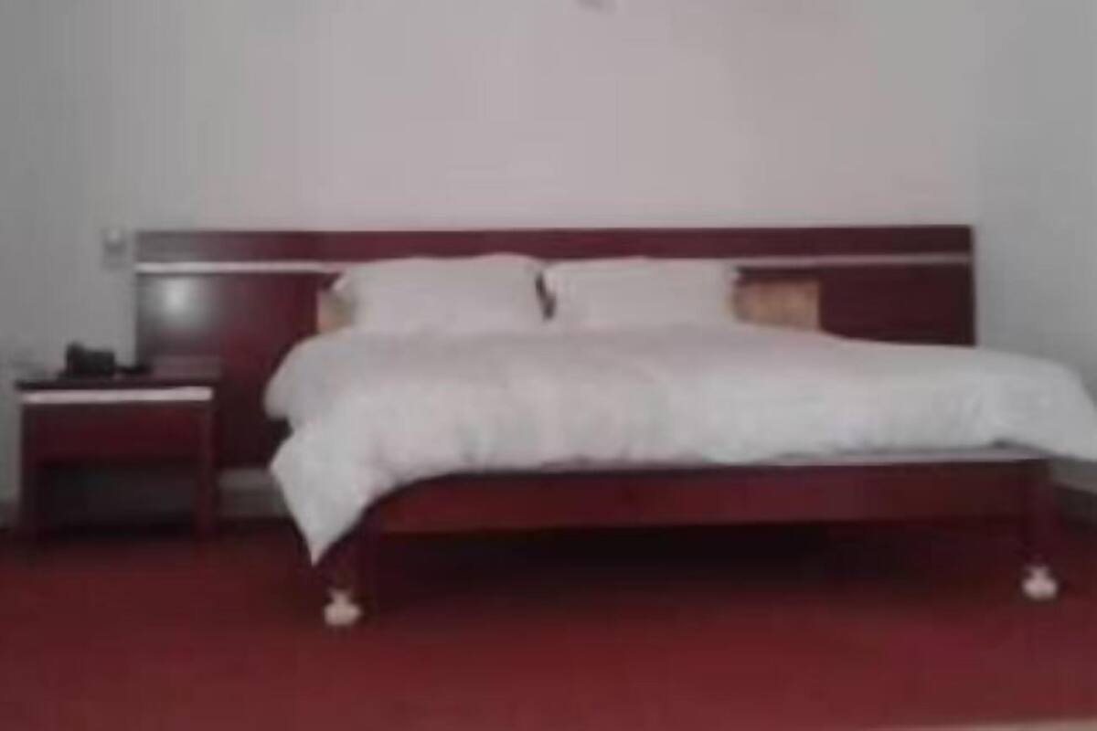 A bedroom with a single bed, a nightstand, and a ceiling fan.