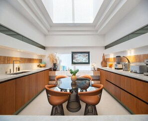 Enjoy meals in the spacious kitchen with a central island and dining area, featuring a large skylight and modern appliances.