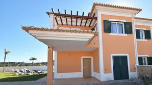 A two-story building with a balcony, a door, and a window with shutters. - Villa Barros, with private swimming pool, in a quiet and peaceful area. (Algoz)