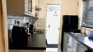 A kitchen with a refrigerator, stove, and sink.