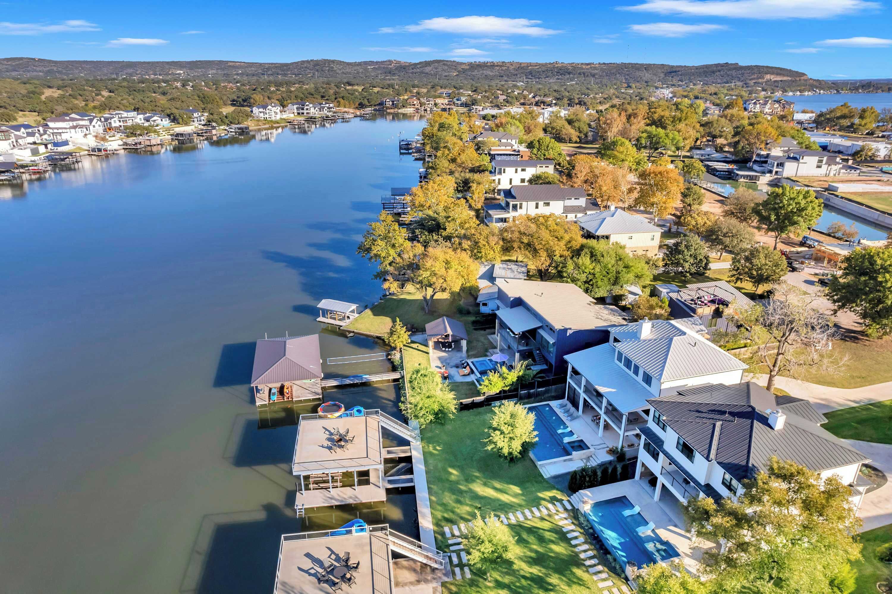 A lakeside residential area with houses, docks, and a swimming pool.