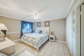 A bedroom with a bed, a desk, a chair, a nightstand, and a ceiling fan. - FREE Golf & Perks! Mariner West 306- Low Floor, Pool, Tennis & BBQ Grills! (Panama City Beach)