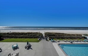 A pool area with lounge chairs and a view of the beach. - FREE Golf & Perks! Mariner West 306- Low Floor, Pool, Tennis & BBQ Grills! (Panama City Beach)