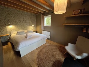 A bedroom with a bed, bedside lamps, a chair, a window, and a radiator. - Gîte de groupe LesQuatreSaisons #Chambord#ChâteauxdelaLoire#Beauval (Maslives)