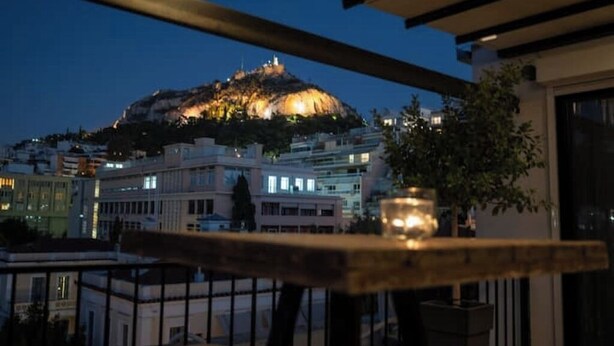 A balcony with a view of a hilltop building at dusk. - Athens Skyline Loft

 (Athina)
