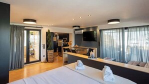 A modern hotel room with a large bed, a dining area, and a kitchen. - Athens Skyline Loft

 (Athina)