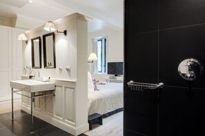 A modern bathroom with a white vanity, two mirrors, a bathtub, and a shower with a glass-enclosed door. - Paris Green House Residence (Paris)