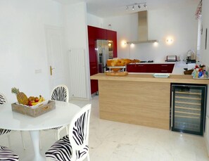 A modern kitchen with a central island, white chairs, and a dining table. - Villa With Golf-course Views (Santa Eulalia del Rio)