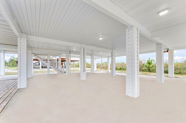An open, covered outdoor area with white columns and a wooden deck.