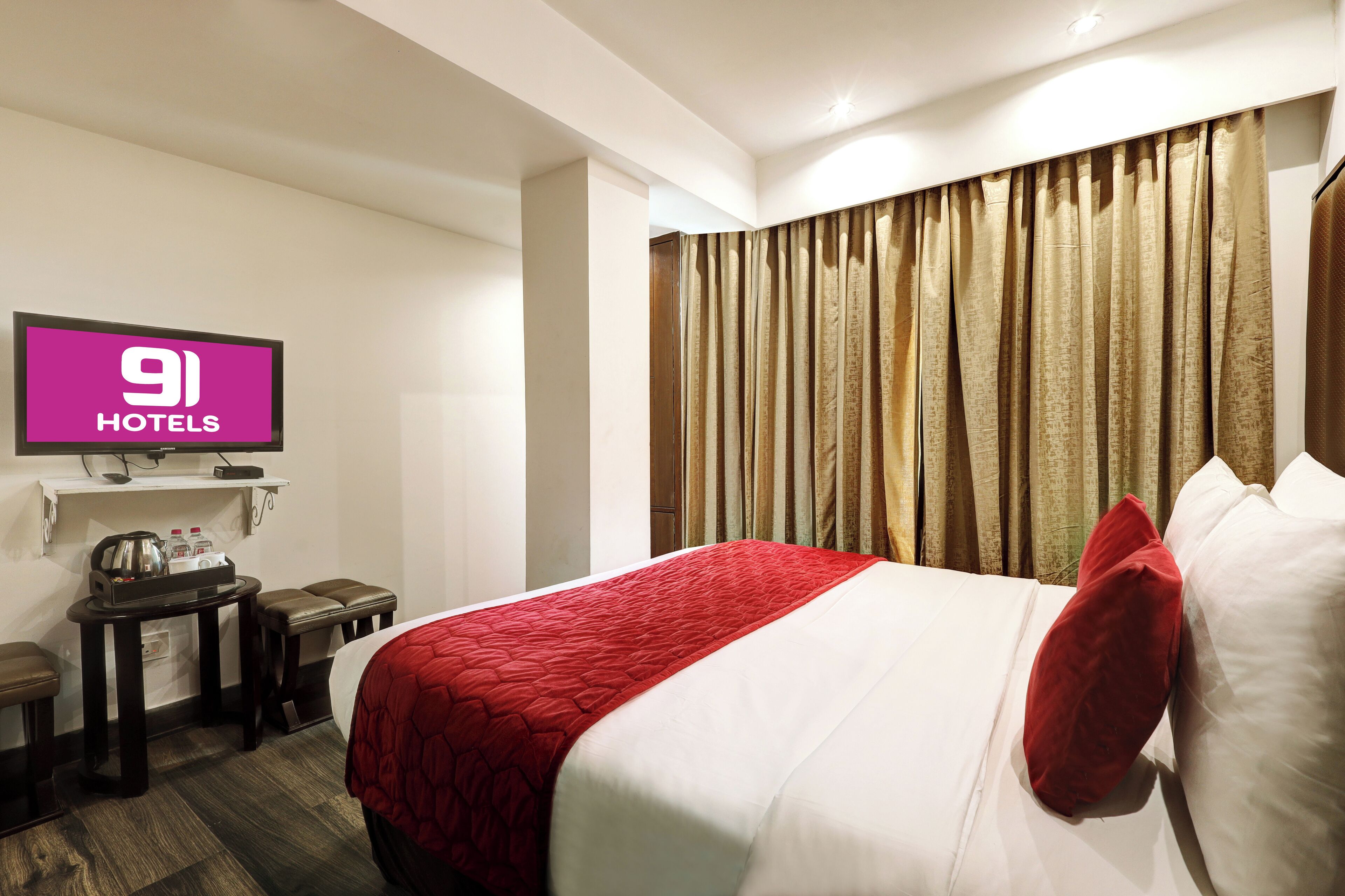 Una habitación de hotel con cama, televisión, escritorio y silla.