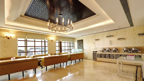 A spacious lobby with a high ceiling, a chandelier, and a seating area with sofas.