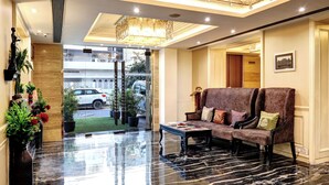 A lobby with a marble floor, a sofa set, and a chandelier.