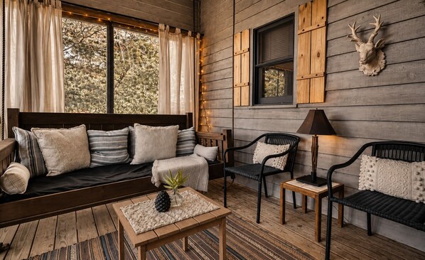 A cozy interior with a wooden bench, cushioned seating, and a lamp. - Easy Access •Mtn View• Hot Tub• Pool• Game Room• Porch• Wildlife•Minutes to Town (Ellijay)