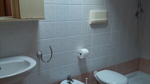 Ein Badezimmer mit Waschbecken, Bidet, Toilette und Dusche.