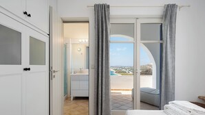 Quarto com cama, banheiro com pia e varanda com vista.