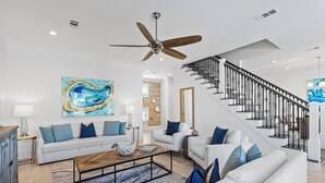 A modern living room with a sofa, coffee table, and artwork. - Private Community Beach - Pool - Gated Community (Destin)