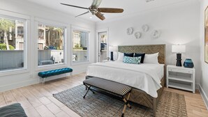 A bedroom with a bed, a bench, a ceiling fan, a nightstand, and a window with blinds. - Private Community Beach - Pool - Gated Community (Destin)