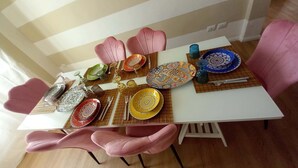 A dining table set with colorful plates, a variety of cutlery, and a decorative centerpiece. - Third floor (Pisa)