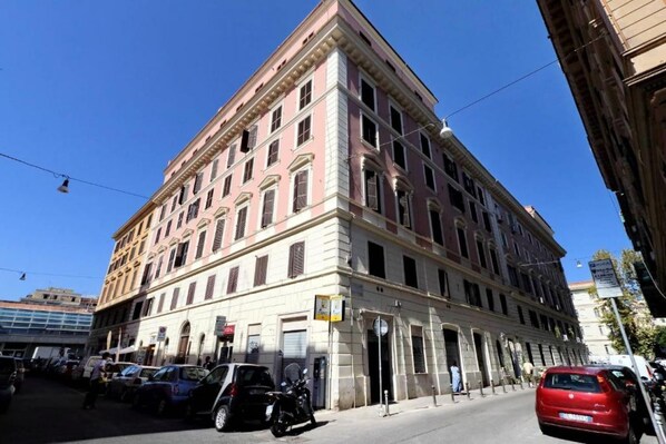 Un immeuble à étages de style architectural classique, doté d’une entrée d’angle et d’un espace commercial situé au rez-de-chaussée.