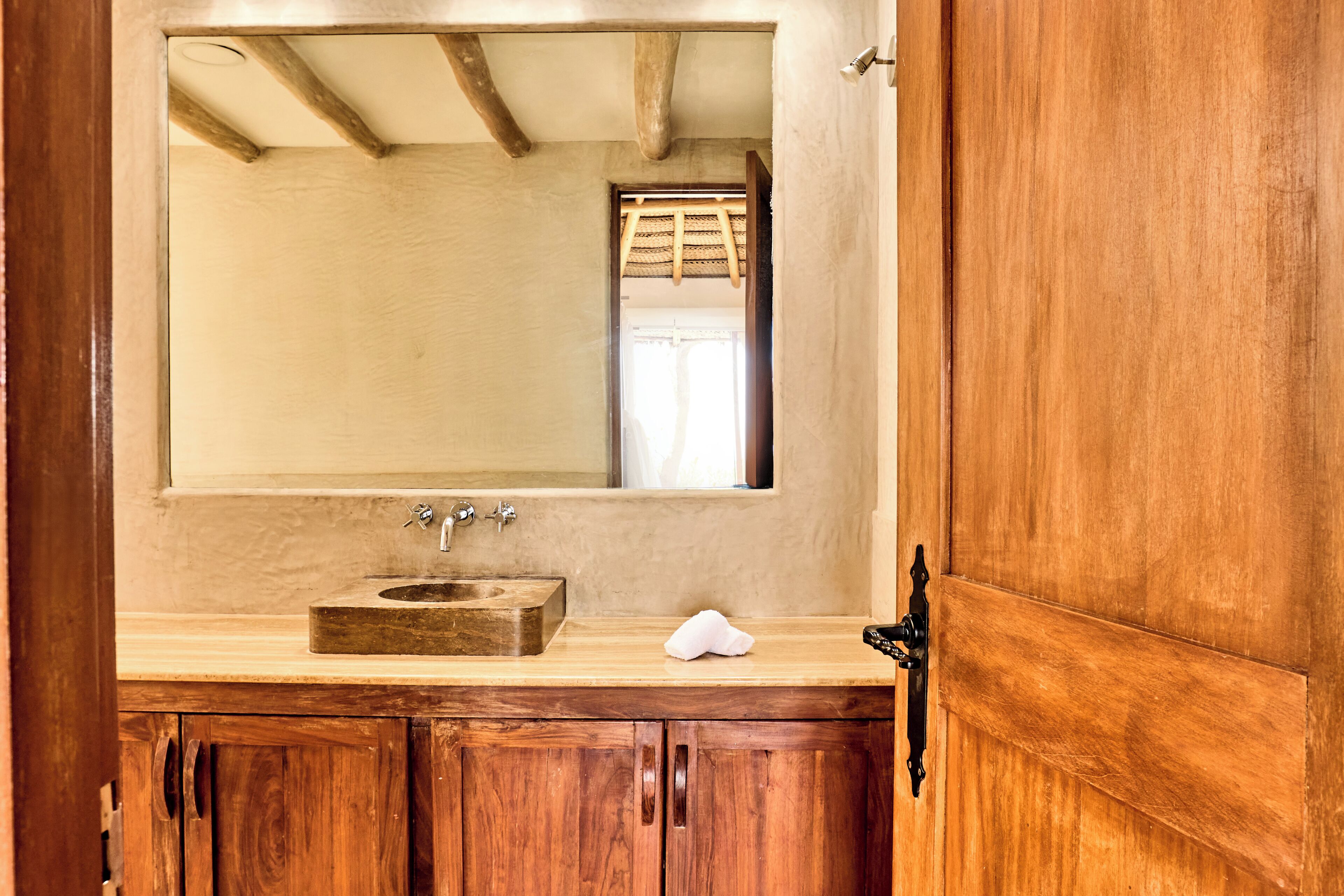 Un tocador de madera con un espejo grande, un lavabo y una toalla.