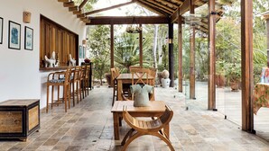 Un patio couvert aménagé avec des meubles en bois, une table et des chaises.