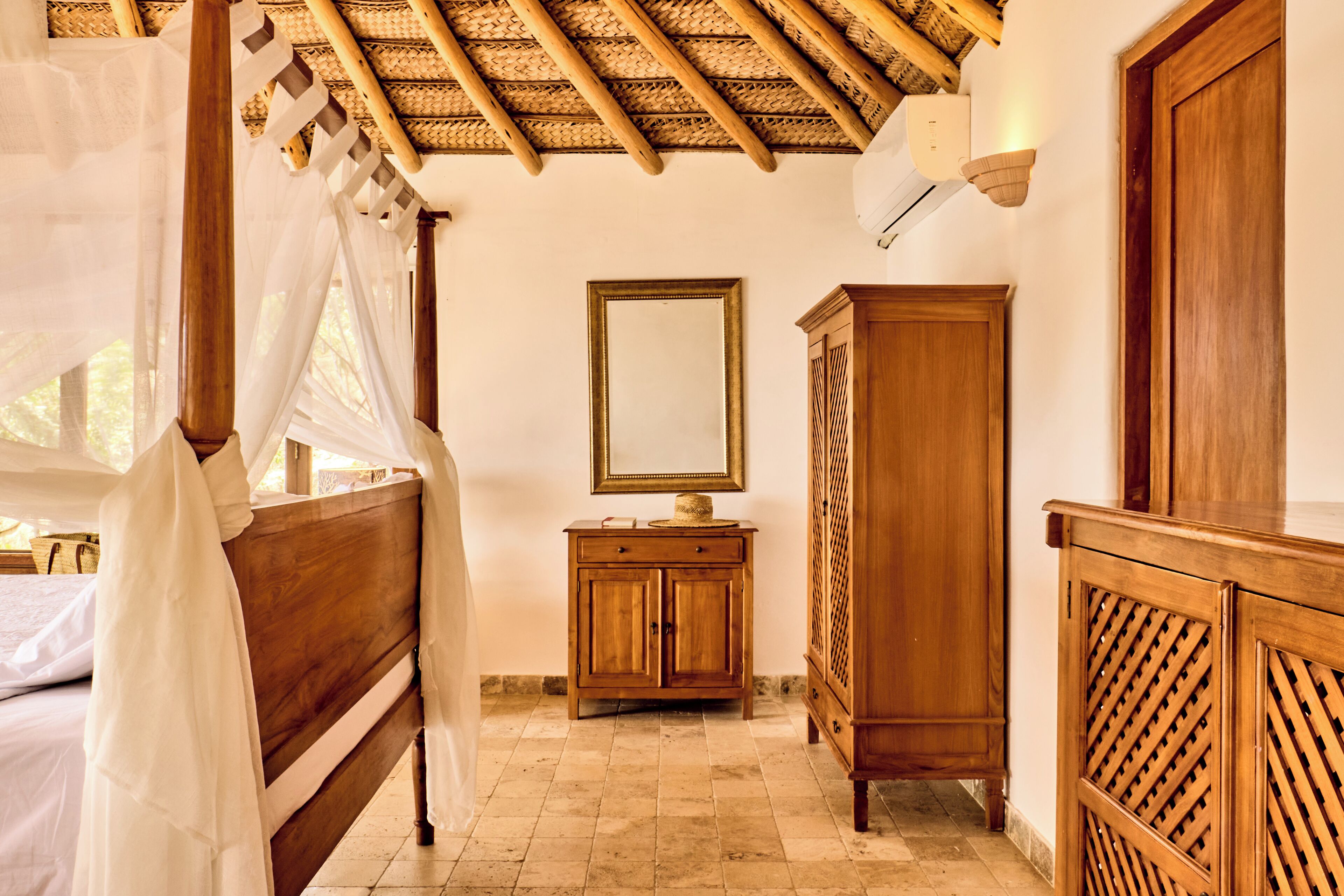 A bedroom with a wooden bed, a nightstand, a wardrobe, and a ceiling fan.