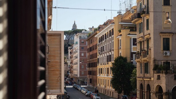 Une rue étroite bordée d’immeubles à plusieurs étages, dont certains sont dotés de balcons et de climatiseurs.