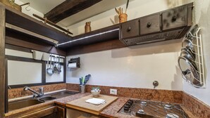 A kitchen with a sink, stove, and wooden cabinets. - Historical Loft with view in city center! (Roma)