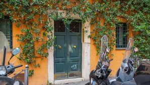 Un edificio con puertas verdes y una motocicleta estacionada frente a él.