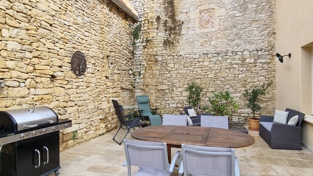 An outdoor patio with stone walls, a grill, and seating. - La Grange, in the heart of Périgord Noir, calm, serene and independent  (DAGLAN)