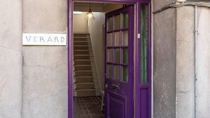 A staircase leading to a purple door with a sign reading "VERARD" above it.
