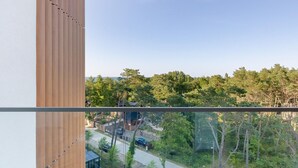 A modern building with a view of a residential area and dense trees. - Beachfront holiday apartment, sauna, swimming pool (Pobierowo)