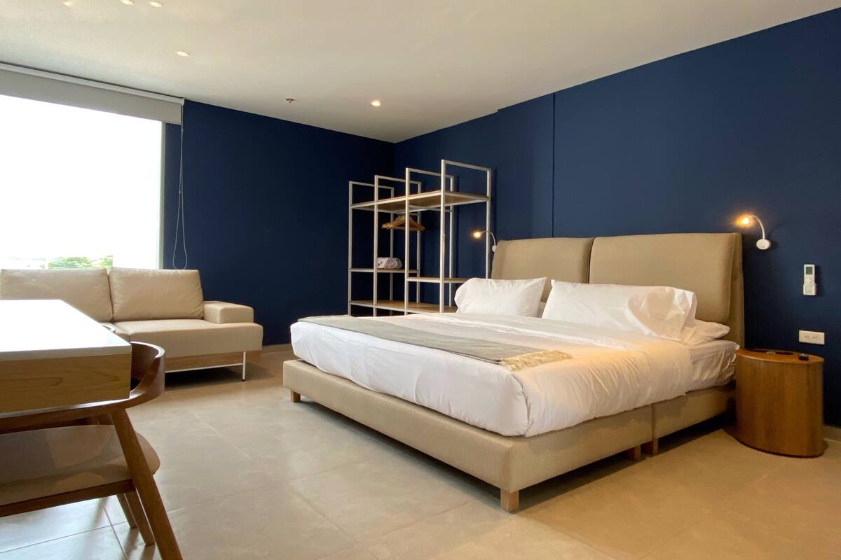 Ein modernes Schlafzimmer mit einem großen Bett, einem Schreibtisch und einem Stuhl.