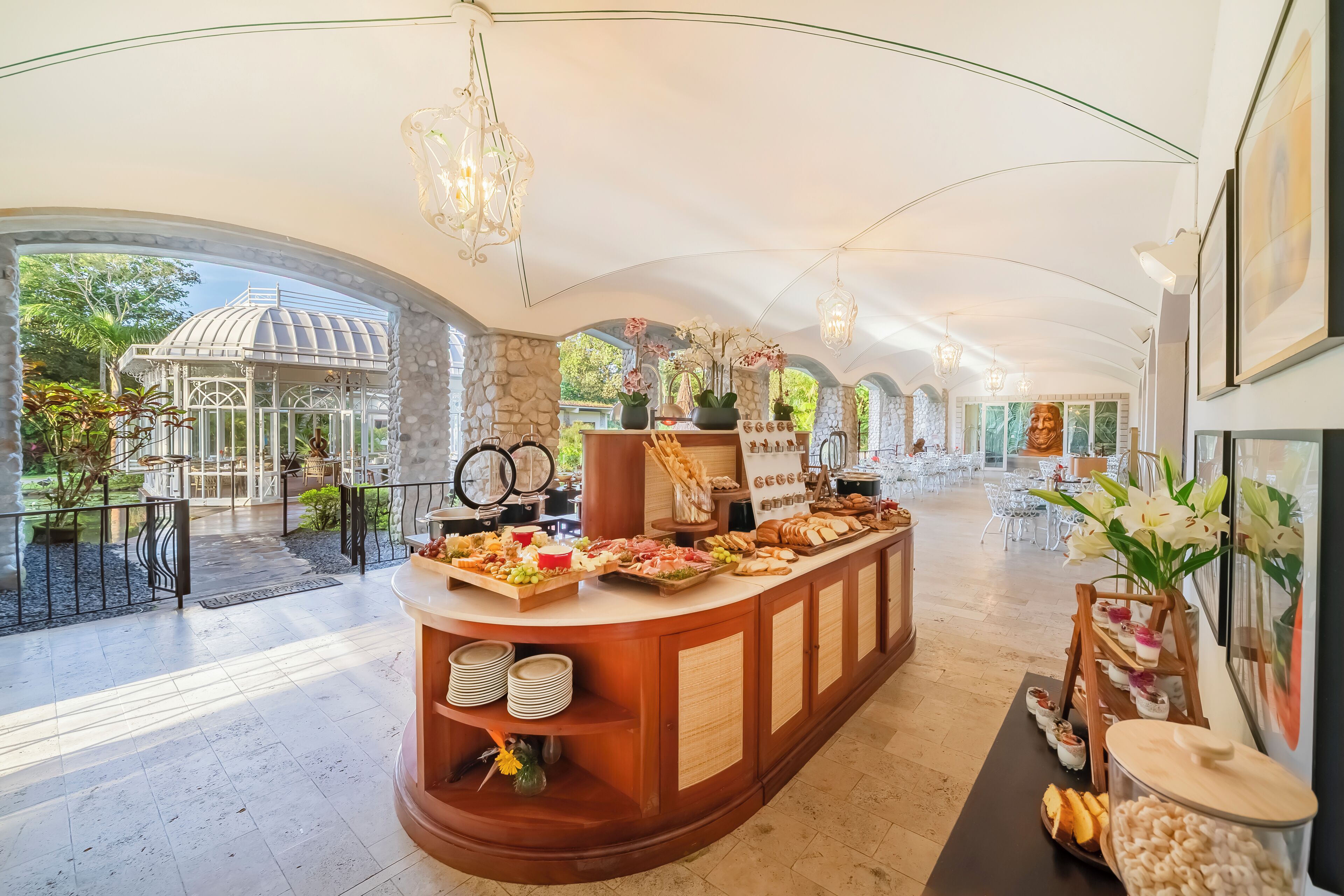 Un vaste espace intérieur doté d’un espace central pour présenter les plats, d’un jardin clos par des parois de verre et d’un aménagement intérieur moderne.